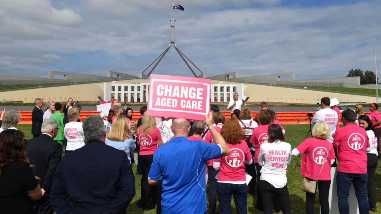 Aged care workers are seen protesting outside Parliament House in Canberra, Wednesday, March 30, 2022.