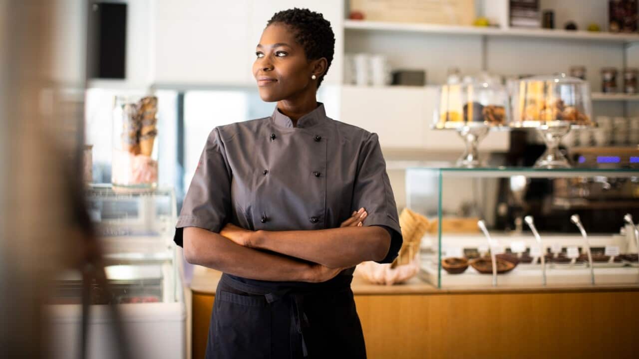 Mjasiriamali asimama mbele ya duka lake