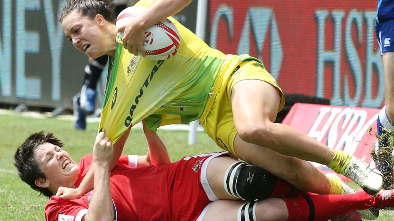 Canada's Charity Williams (L) tackles Australia's Emilee Cherry