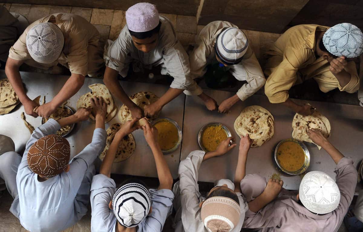 students eat a meal at a seminary in Karachi, Pakistan