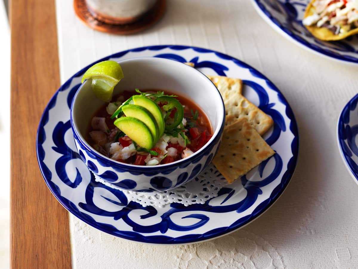 Ceviche-rojo (marinated seafood) is served with plain crackers.