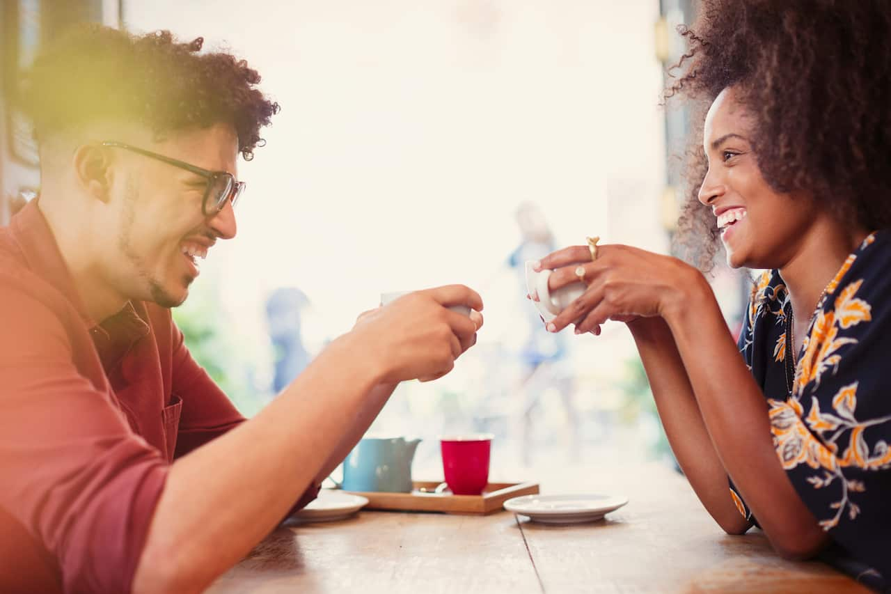 Couple drinking coffee face to face in cafe