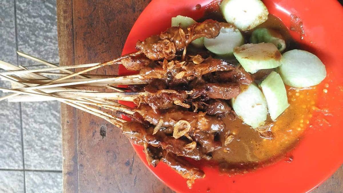 Sate ayam Madura served with peanut sauce and topped with fried shallots.