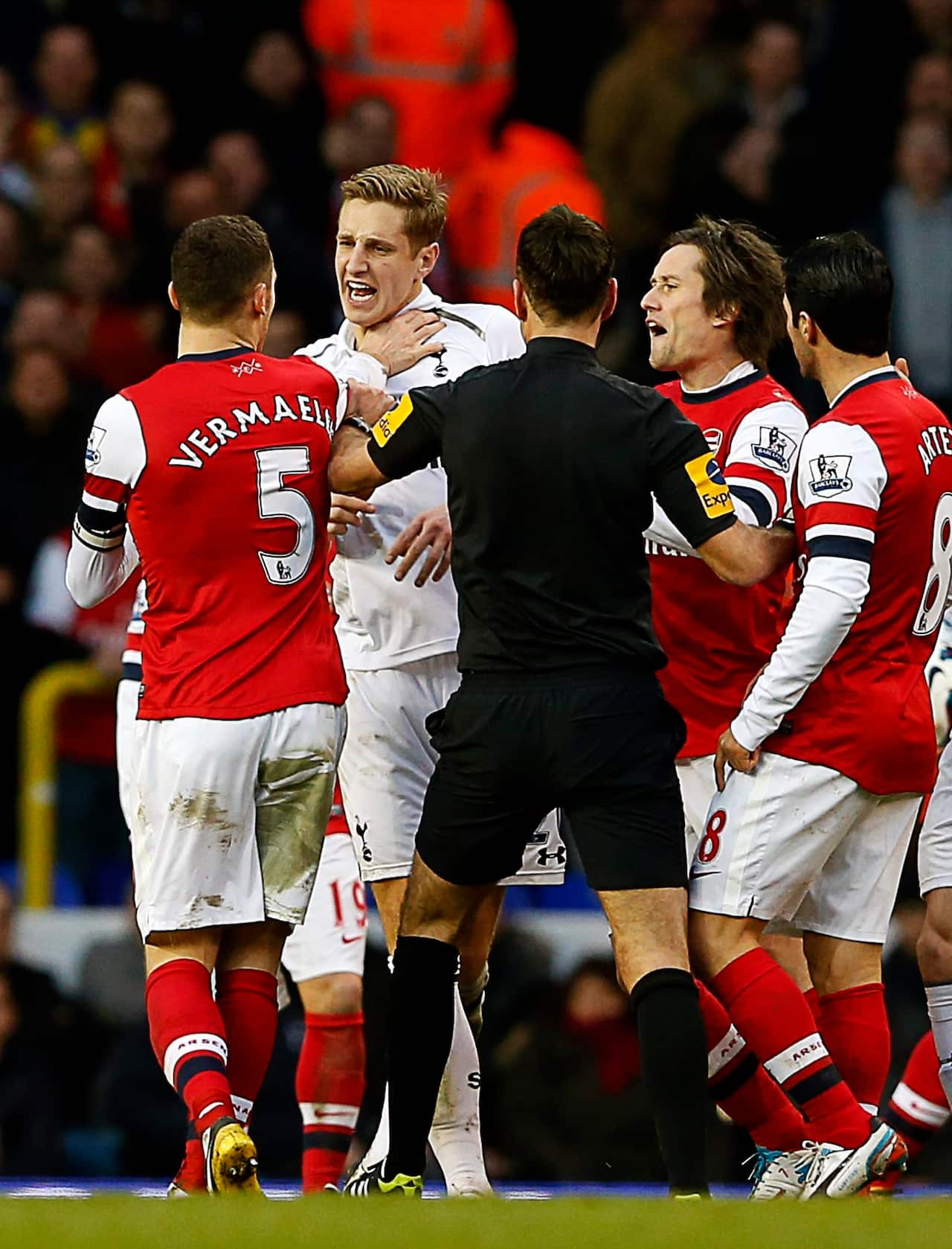 Michael Dawson of Tottenham Hotspur (2nd L) argues with Thomas Vermaelen of Arsenal (L) during a Premier League match in 2013.