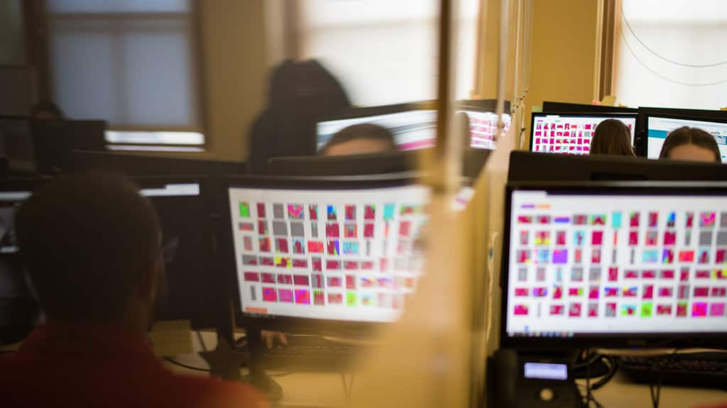 Workers at the hotline, the Canadian Center for Child Protection, reviewing evidence of sexual abuse. The pictures are in an altered format that analysts use to protect the victims. 