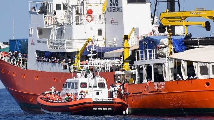 An Italian Coast Guard boat approaches the French NGO "SOS Mediterranee" Aquarius ship as migrants are being transferred, in the Mediterranean Sea, June 12.