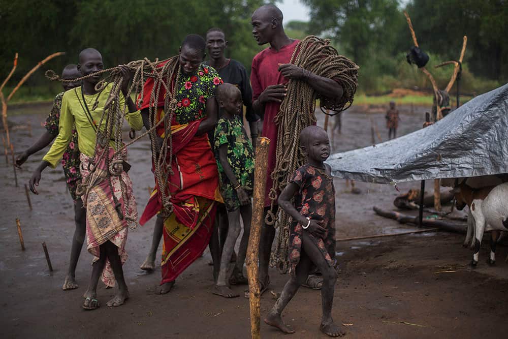Tribesmen wait for their cattle to return to camp. Ropes are used to tie the animals to stakes overnight. (Matthew Abbott)