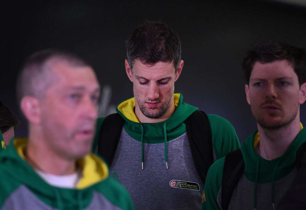 Daniel Kickert of the Boomers (centre), the Australian national basketball team, listens to coach Andrej Lemanis (left) on arrival at Brisbane airport.