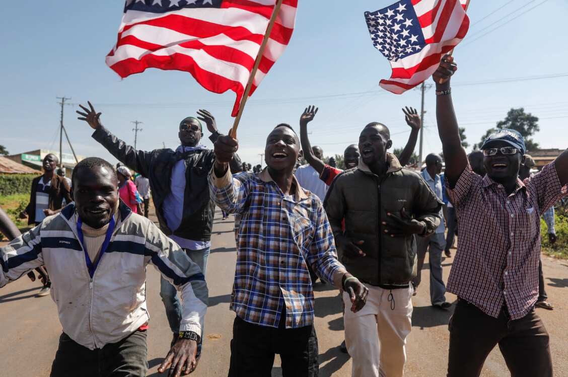 Supporters of former US president Barack Obama wave US flags in Kogelo, Kenya.