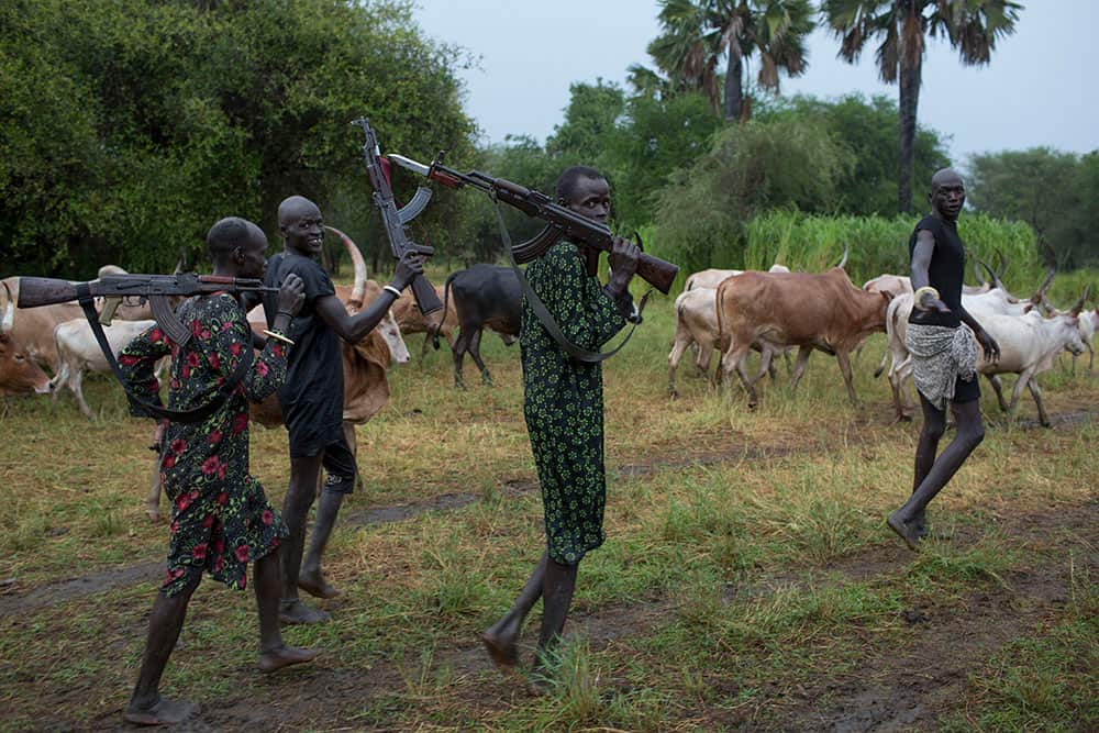 Tribesmen casually stroll back to camp when they realise they're not being raided or attacked by a rival clan. (Matthew Abbott)