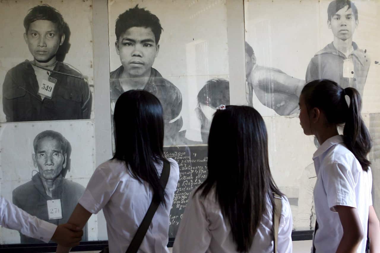 A file photo of Cambodian students viewing photographs of Khmer Rouge victims at Tuol Sleng Genocide Museum, in Phnom Penh, Cambodia, 27 March 2009.