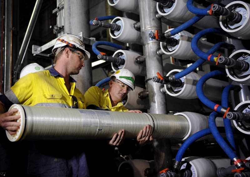 Desalination plant employees demonstrate the loading of a reverse osmosis filter at Sydney's Desalination Plant.