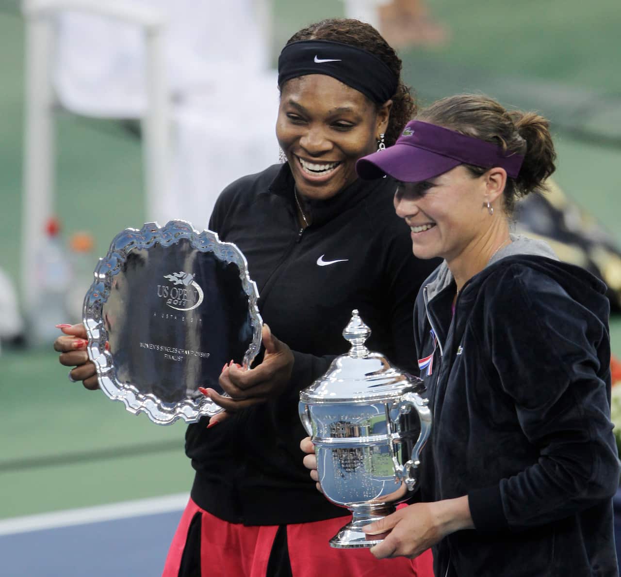 Samantha Stosur of Australia and Serena Williams  pose with the trophies at the U.S. Open 2011