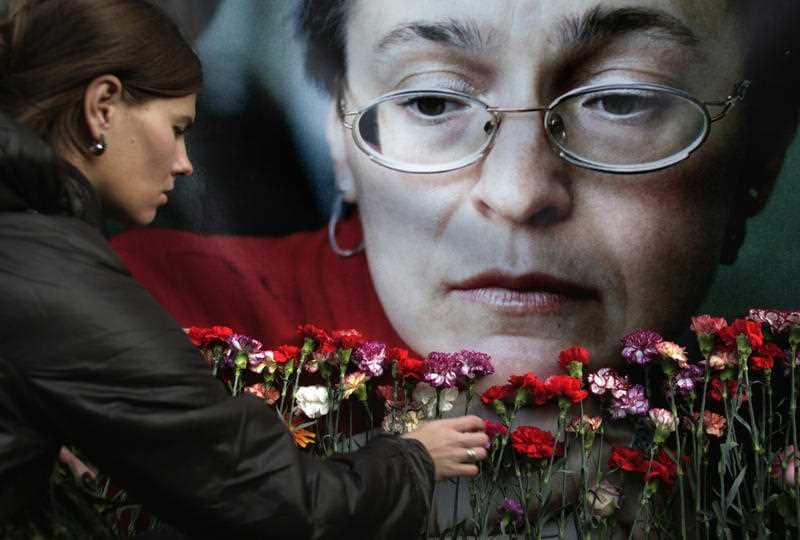 A woman places flowers before a portrait of slain Russian journalist Anna Politkovskaya, in Moscow, in this file photo dated Wednesday, Oct. 7, 2009.