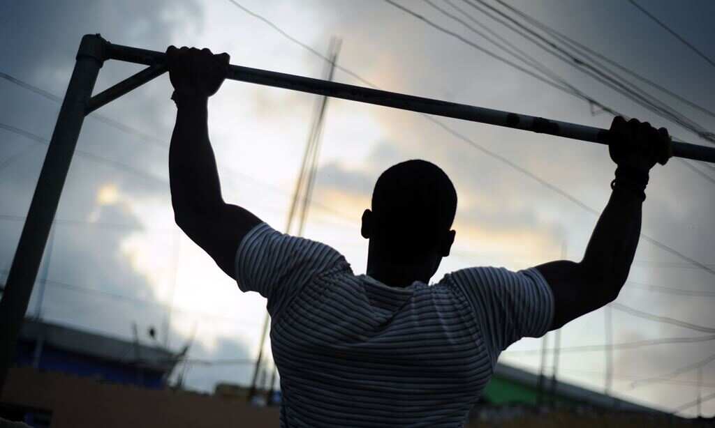 A young man does pull-ups in a gym in the Jalousie neighborhood of Petionville, a suburb of Port-au-Prince on April 11, 2014. (AFP)