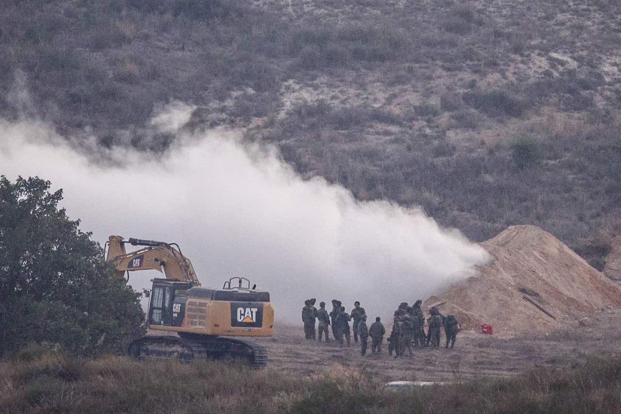Israeli soldiers spray gas at the exit of a tunnel which was used the day before by Hamas militants to infiltrate Israeli lines, on July 22, 2014 (AFP)