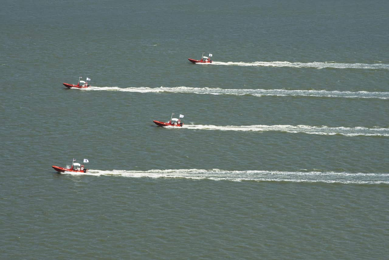 Four unmanned remotely operated high-speed maneuvering surface targets move to their blocking positions during a demonstration of autonomous swarmboat technology. (AFP)