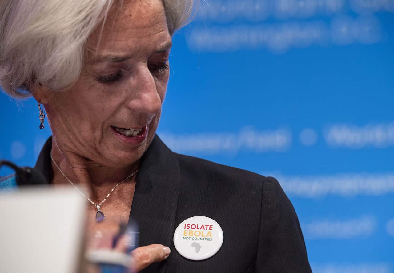 IMF Managing Director Christine Lagarde points to a badge reading "Isolate Ebola Not Countries"