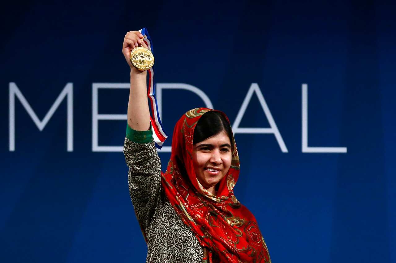 Malala Yousafzai holds up her Liberty Medal during a ceremony at the National Constitution Center in Philadelphia. (AAP)