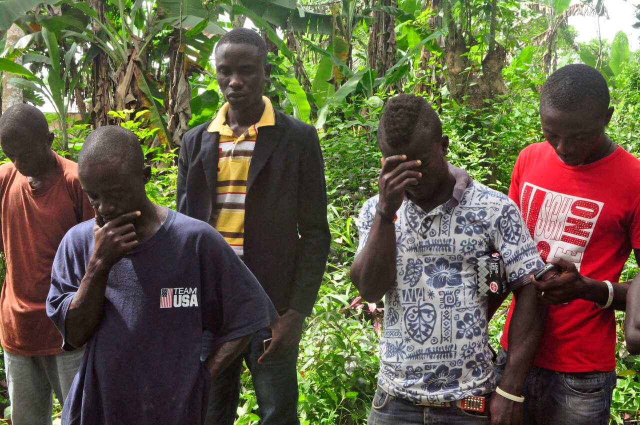 Relatives react as the lifeless body of their family member is carried away by health workers, after he died suspecting he contracted the Ebola virus (AAP)