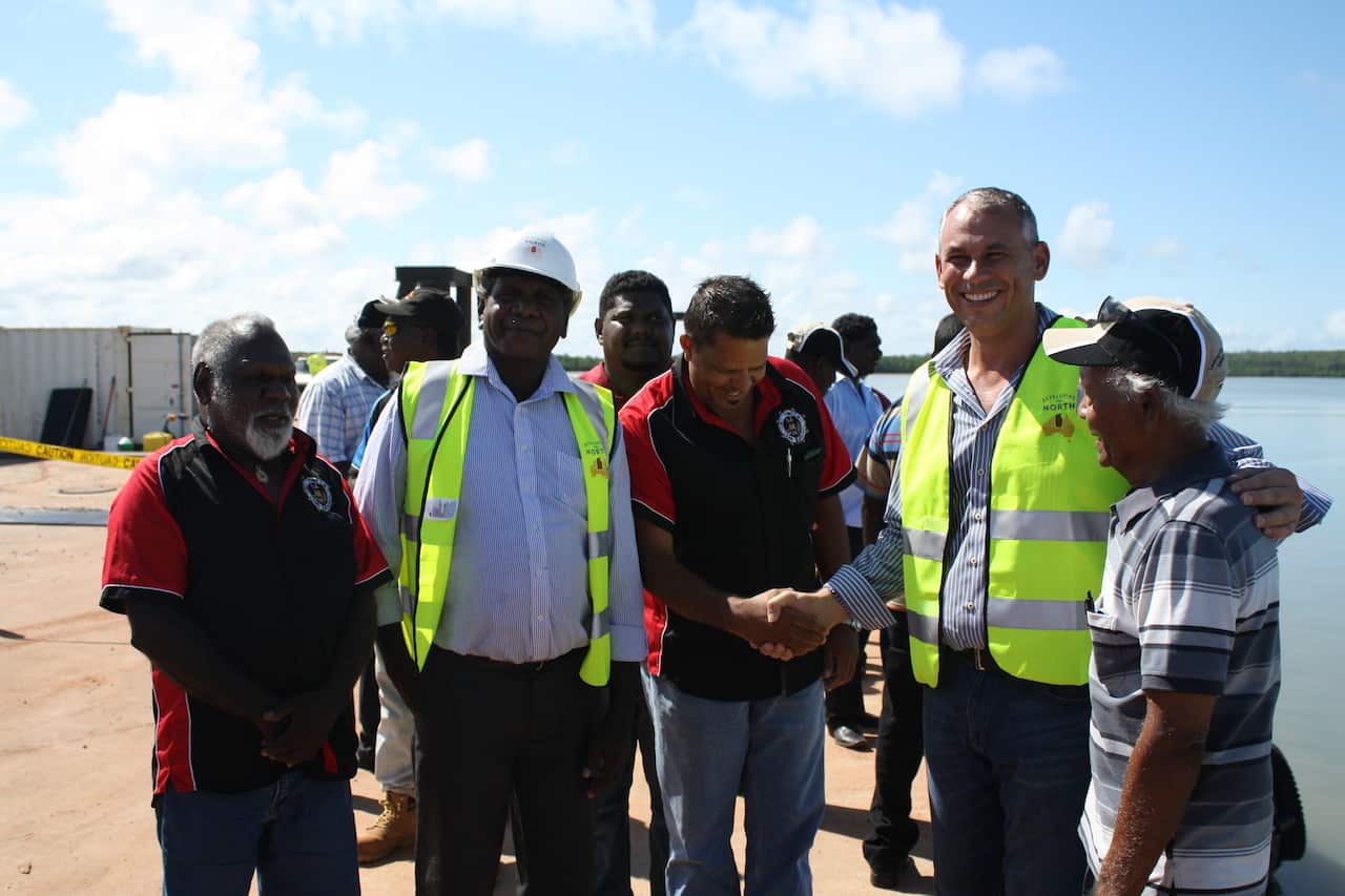 Northern Territory Chief Minister Adam Giles, second from right, with Tiwi islands elder Cyril Kaaippa Rioli as he shakes hands with Port Melville chairman Andrew Tipungwuti on Melville Island, March 5, 2015. (AAP/Neda Vanovac)