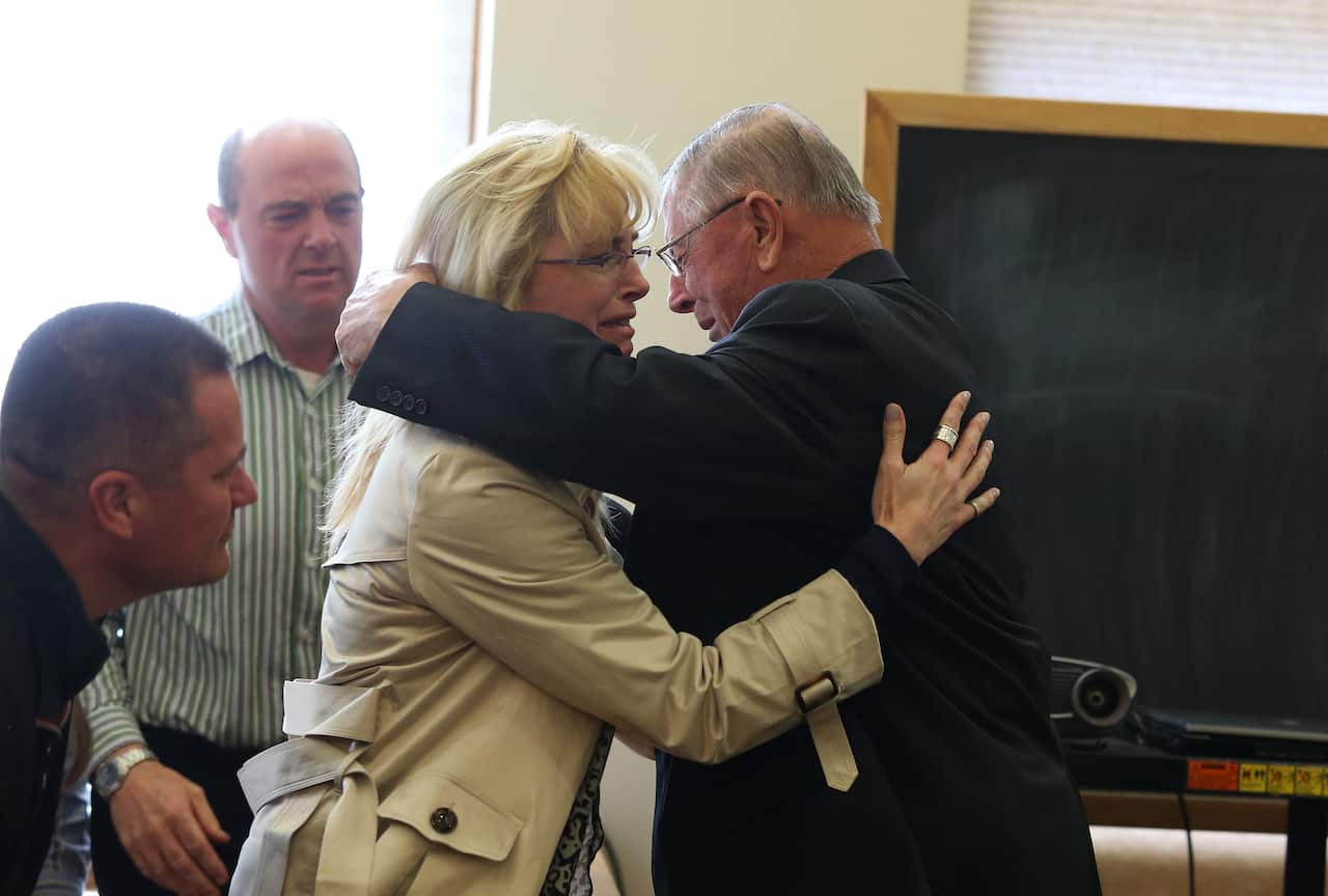 Henry Rayhons hugs members of his family after being found not guilty of sexual abuse.