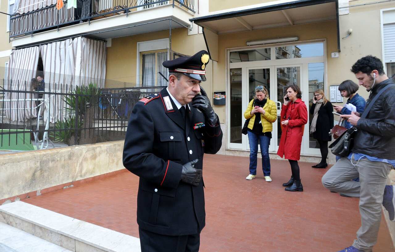 Journalists and Italian Carabinieri paramilitary police officers stand in front of Italian aid worker Giovanni Lo Porto's family house in Palermo, Sicily, Italy, Thursday, April 23, 2015 (AP Photo/Alessandro Fucarini)