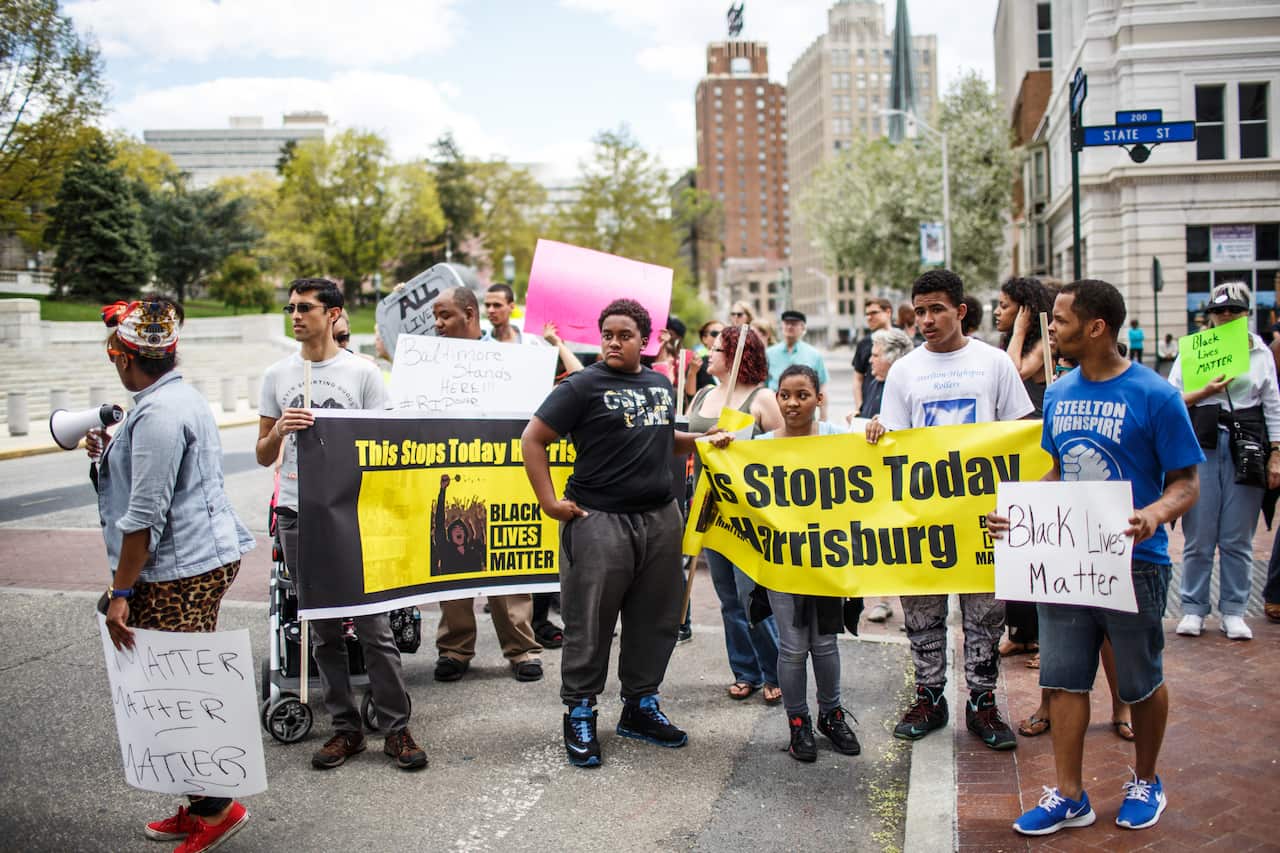 Festive Baltimore rallies in hope after police charged