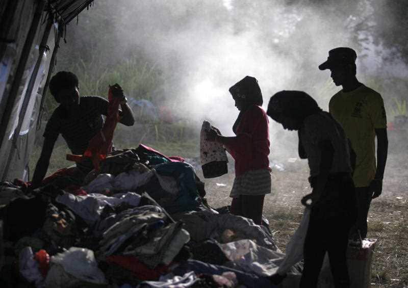   Ethnic Rohingya migrants sift through used clothing donated by local residents at a temporary shelter in Langsa, Aceh province, Indonesia. (AP Photo/Binsar Bakkara, File)