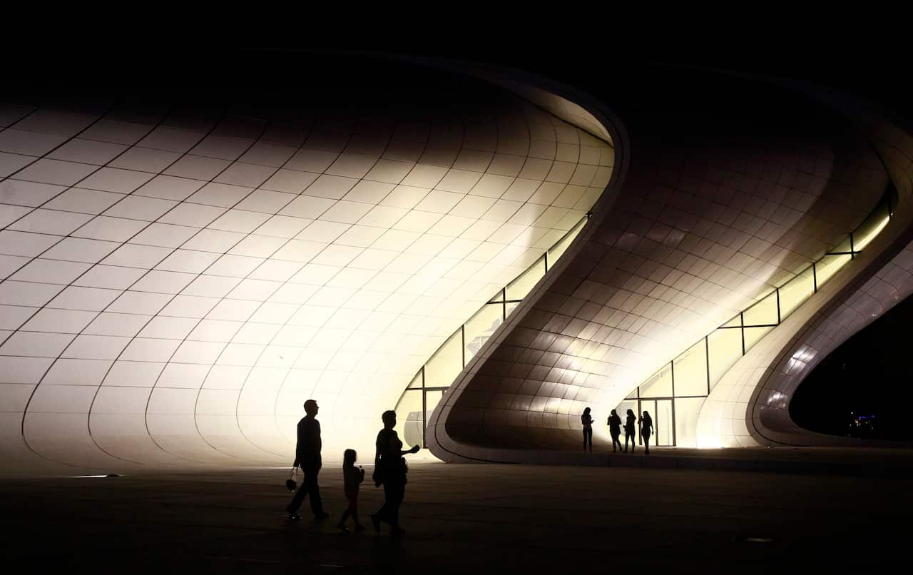 People standing in front the Heidar Aliyev Cultural Centre in Baku, Azerbaijan, 22 June 2015. The building was designed by Iraqi-British architect Zaha Hadid 