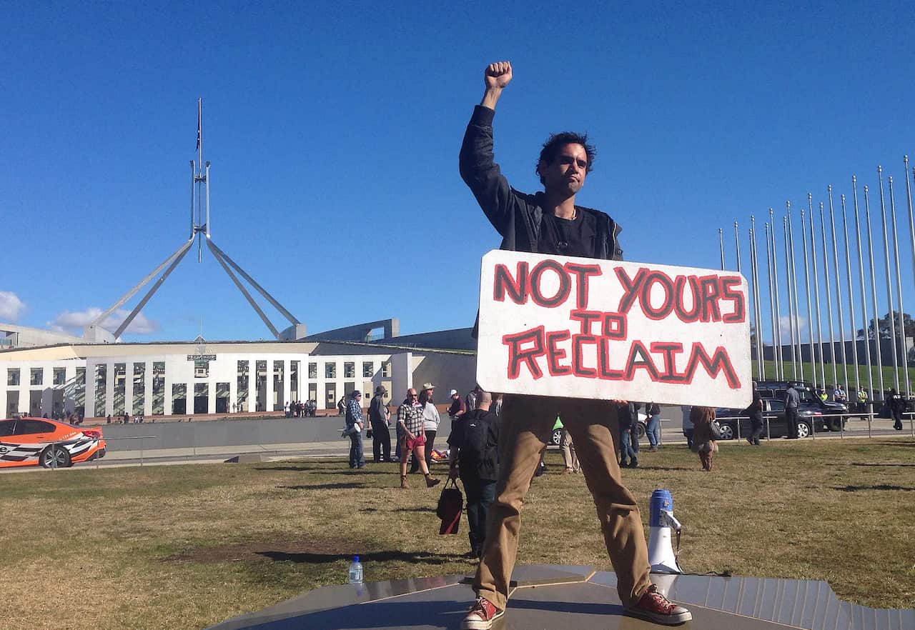 A protester holds a sign during a march toward parliament at a Reclaim Australia Rally in Canberra, Sunday, July 19, 2015. (AAP Image/Elise Scott) NO ARCHIVING