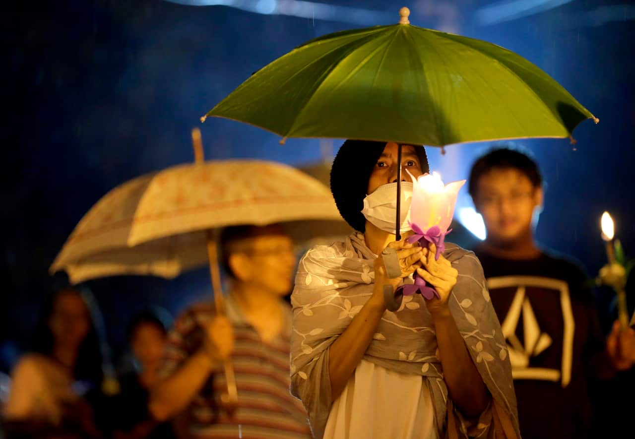 Peoples light the candles and walk around during a downpour for religious merit making to celebrate the Buddhist Lent or 'Khao Pansa' at Wat Benchamabophit.