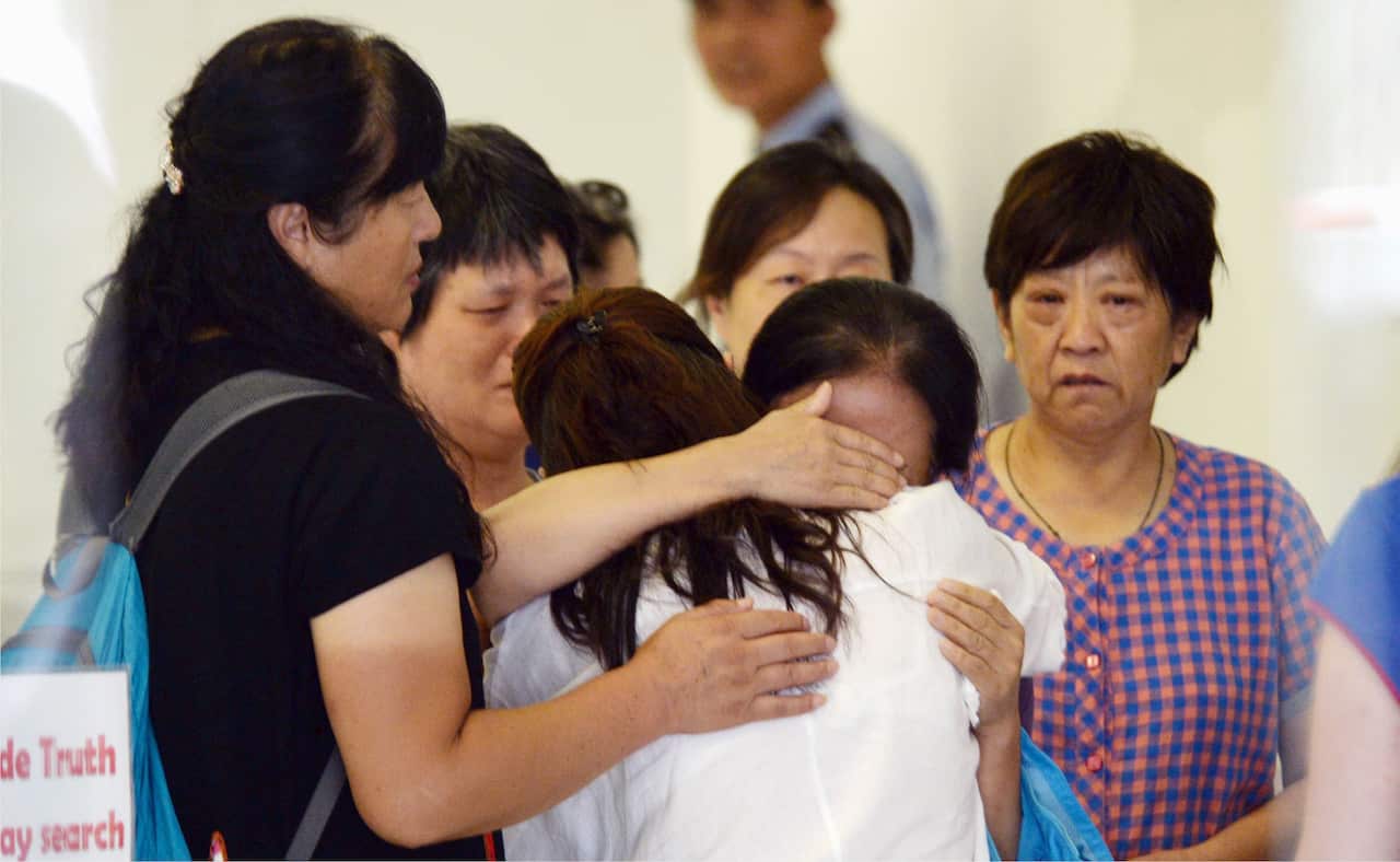 About a dozen Chinese family members and relatives of victims aboard Malaysian Airlines flight MH370, which went missing in March last year, gather in the lobby of the airline's office in Beijing on Aug. 6, 2015, to protest. (Kyodo)==Kyodo
