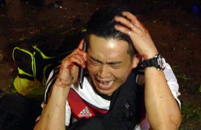A man talking into a mobile photo after an explosion in central Bangkok, Thailand, on Monday, Aug. 17, 2015. (Photo via AP Video)
