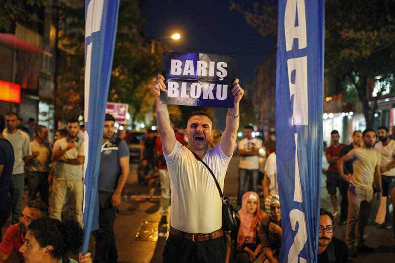 A man protesting against Turkey's operations against Kurdish militants holds a sign that reads in Turkish: "Peace Block" , in Istanbul, Wednesday, Aug. 19, 2015. (AAP)