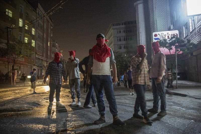 Protestors stand as they clash with Turkish police during an anti-government protest in Istanbul, Turkey, 19 August 2015. (AAP)