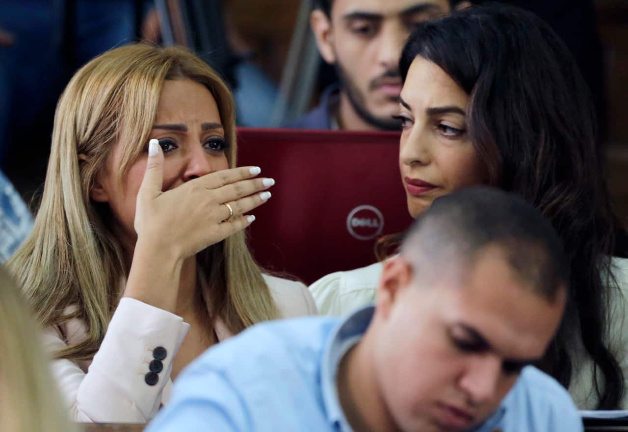 Marwa Fahmy wife of Canadian Al-Jazeera English journalist Mohammed Fahmy, bursts into tears, as she is watched by human rights lawyer Amal Clooney, after the verdict in a courtroom in Tora prison in Cairo