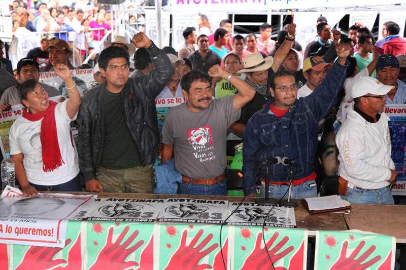 Relatives of of the 43 missing students from the Isidro Burgos rural teacher's college, hold up their fists during a press conference after a meeting with Mexico's President Enrique Pena Nieto, in the Zocalo, Sept. 24, 2015