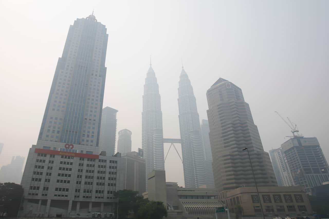 Malaysia's landmark building, Petronas Twin Towers, center, and other commercial buildings stand shrouded with haze in Kuala Lumpur, Malaysia.