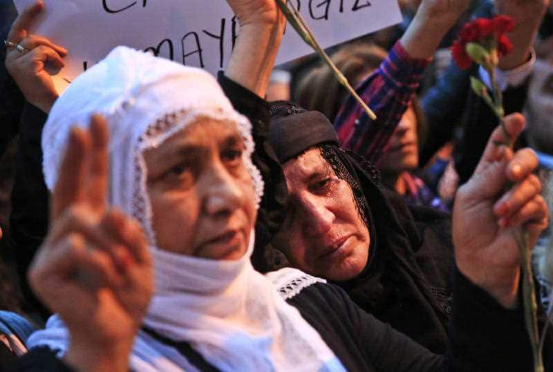 A demonstrator weeps as people flash the V-sign during a rally to protest against the bombing in Ankara earlier, in central Istanbul