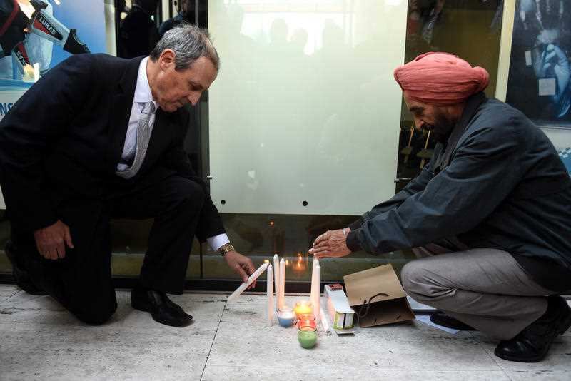 Members of the local community light candles at a vigil for Curtis Cheng in Sydney on Wednesday, Oct. 14, 2015. Mr Cheng, a police accountant, was shot by 15-year-old Farhad Jabar Khalil Mohammad outside the NSW police headquarters on Friday, October 2. (