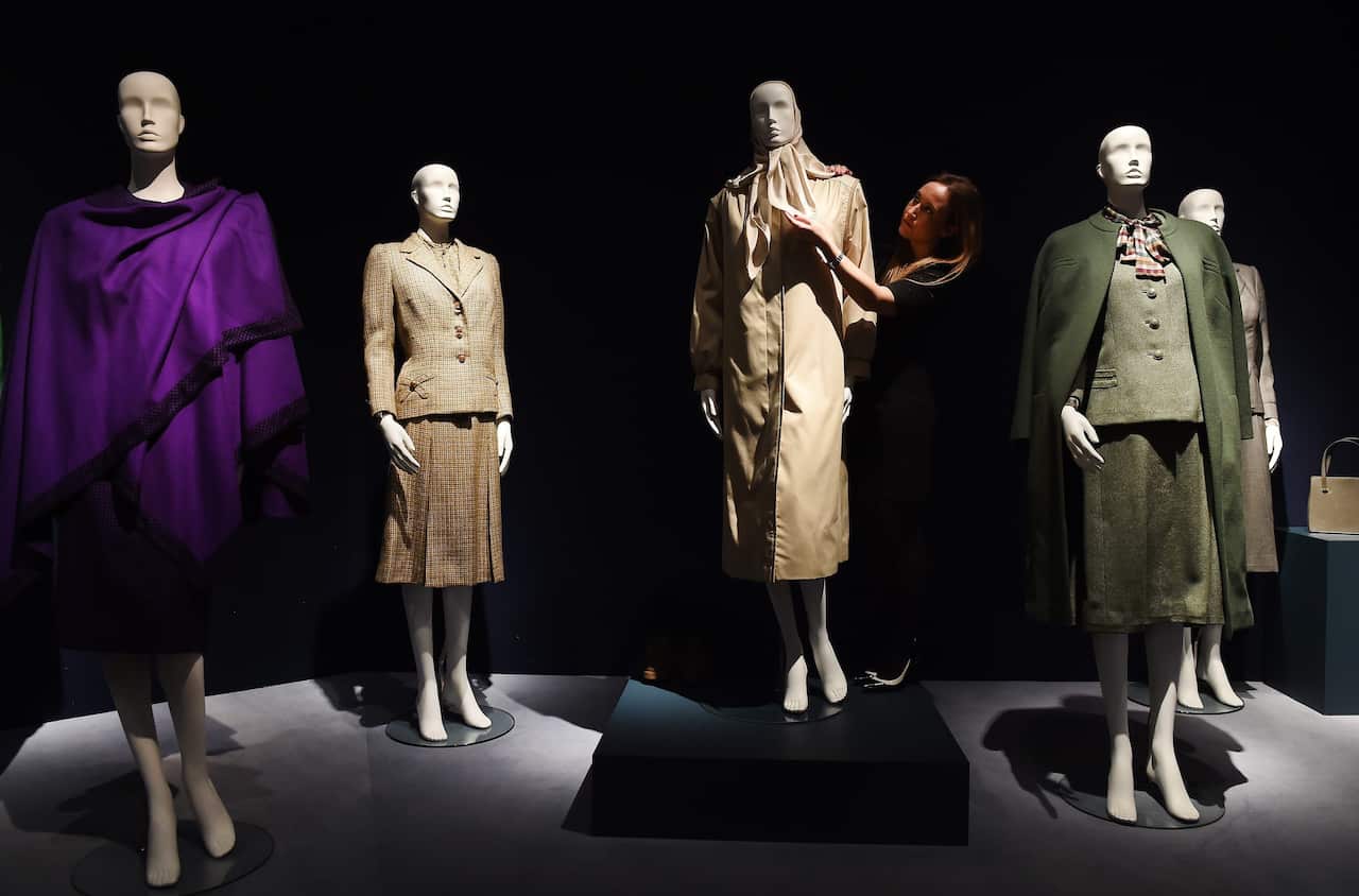 A Christie's staff arranges clothes owned by Margaret Thatcher on display during the sale of Margaret Thatcher's collection at Christie's auction house in London