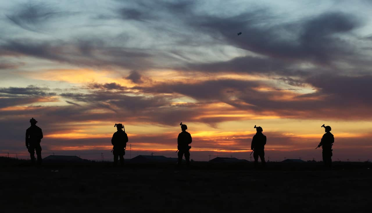 Aussie diggers secure an area prior to the Iraqi soldiers starting their night time activities in Taji, Iraq.