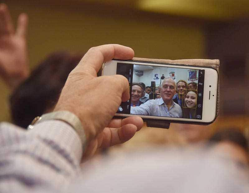Prime Minister Malcolm Turnbull makes a visit to Cairns, Sunday, Feb. 14, 2016. Malcolm Turnbull (C) takes a selfie with Sami Bukholz (R).