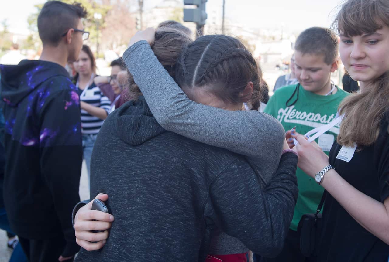 Unidentified young people embrace after being evacuated on Capitol Hill following a shooting in the Capitol Visitors Center, in Washington DC.