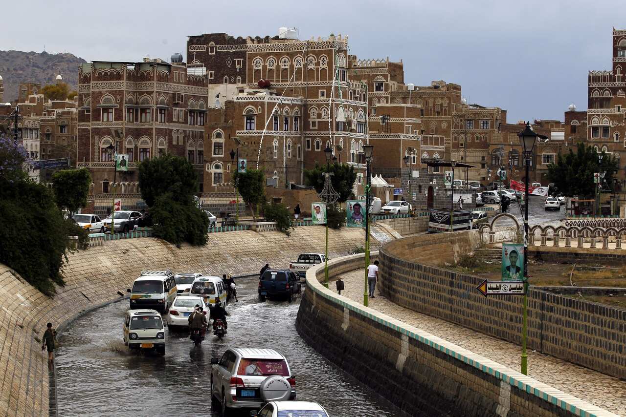Vehicles drive on a flooded street in front of historic buildings in rainy day at a market ahead of a UN-announced ceasefire in the old city of Sana'a. (EPA)