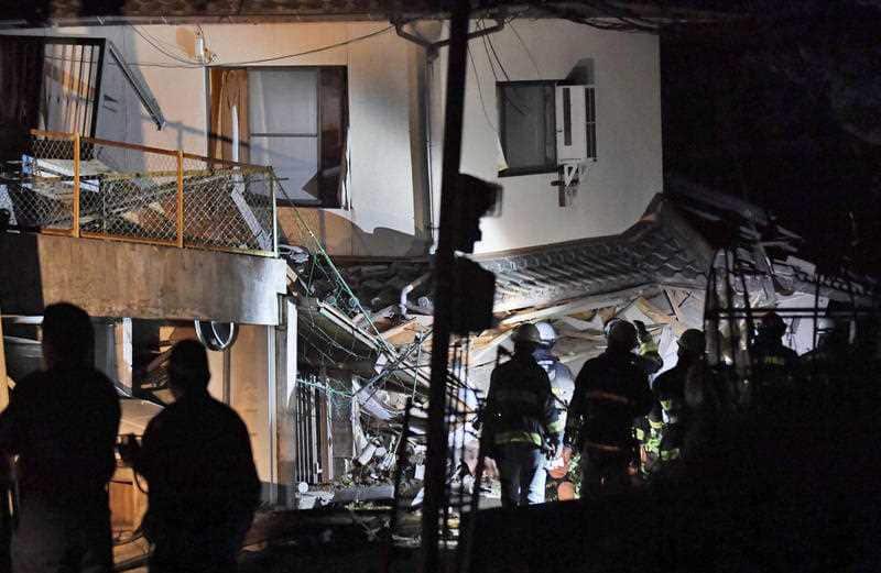 Firefighters search for trapped residents at a collapsed house in Mashiki, near Kumamoto city, southern Japan, after the earthquake early Friday, April 15, 2016