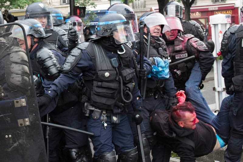 Riot policemen arrest a demonstrator as clashes between demonstrators and riot policemen erupt during a protest against controversial labor reform