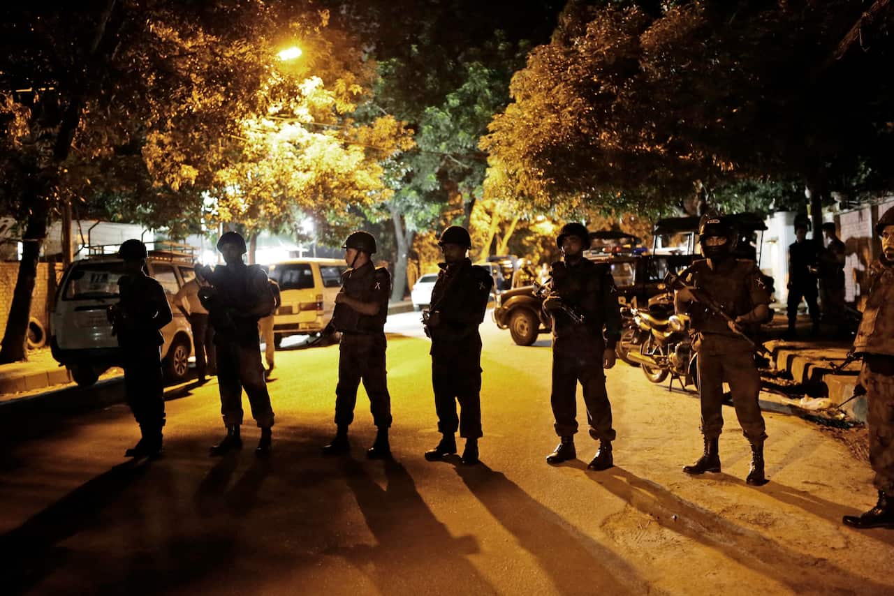 Bangladeshi security forces stand guard as they seal off the streets close to a Spanish resturant, following a hostage taking, in Dhaka, Bangladesh.