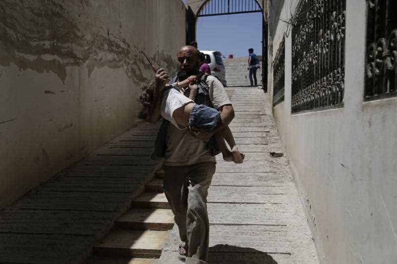 Abdulmonam Eassa's photo of a doctor carrying a wonuded child in Eastern Ghouta. 